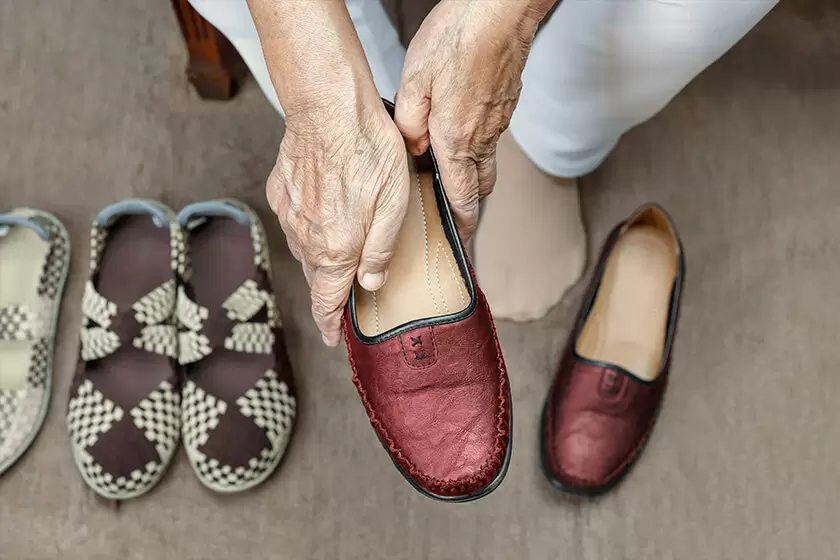 elderly-woman-putting-on-shoes